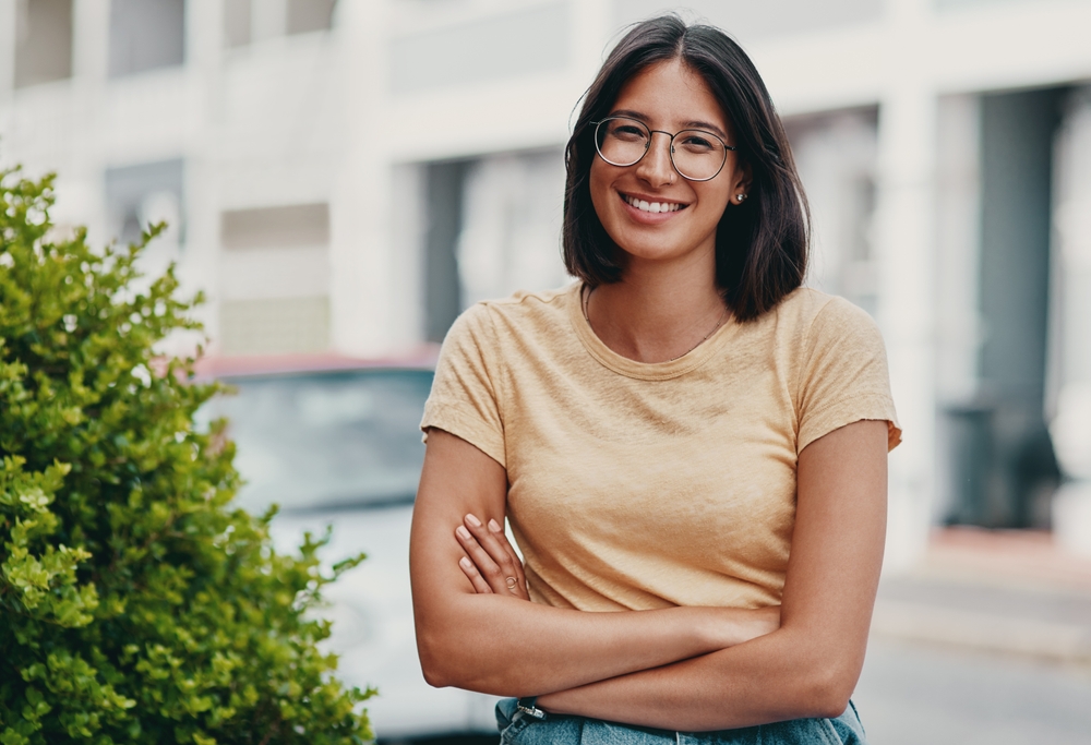 Confident, girl and portrait with glasses outdoor for eyesight or clear vision, optometry wellness and prescription lens. Female student, spectacles and smile for eye care and ocular surface disease.