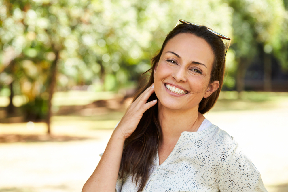 Gorgeous woman smiling in park, portrait