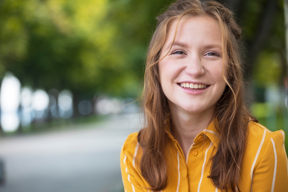 fun portrait of beautiful smiling girl at the park 